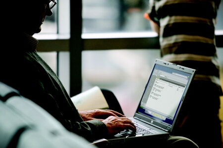 M man sitting in airport terminal using HP Pavilion dv5000