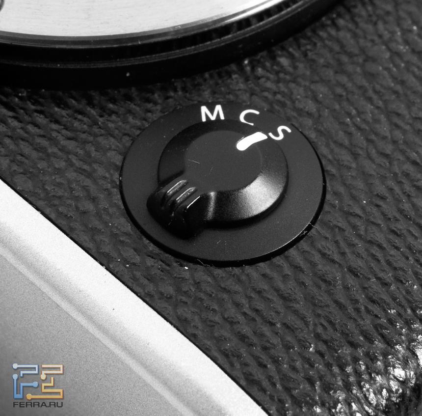 Переключатель режима автофокуса на лицевой стороне корпуса Fujifilm X-E1