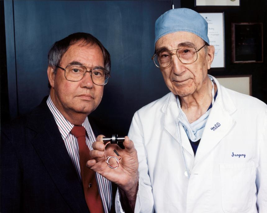 Доктор Майкл Дебейки (справа) держит MicroMed-DeBakey VAD (устройство для помощи желудочкам), крошечный насос для помощи сердцу. С ним один из его пациентов, перенесших операцию по пересадке сердца, Дэвид Саусье, инженер Космического центра имени Джонсона