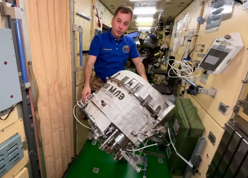 Космонавт Олег Платонов демонстрирует установку